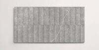 A single dark grey 10" x 30" stone-like porcelain tile with a textured blind pattern and subtle veining