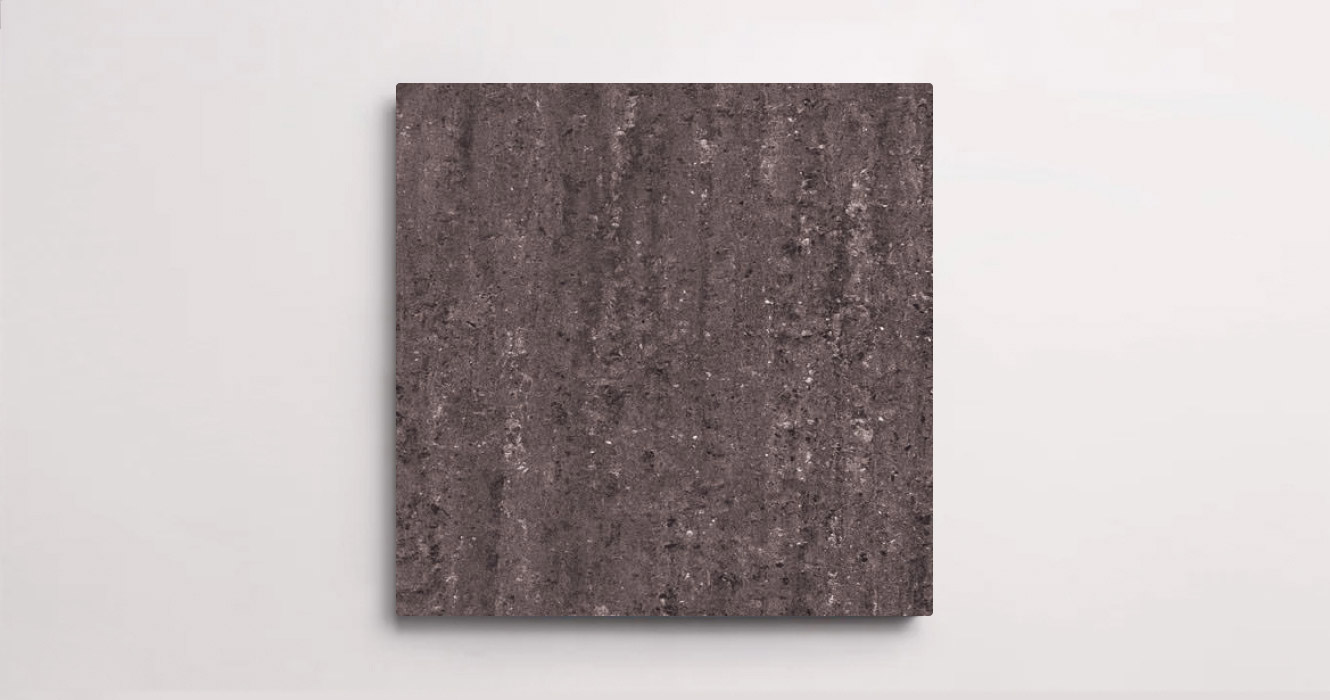 Nasco Stone + TIle's 24" x 24" Angola Charcoal, featuring black and white specks that create a natural, textured appearance.